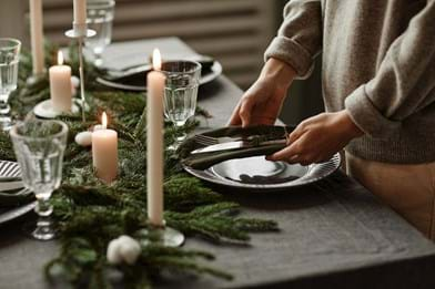 Christmas table setting with real tree plates cutlery and linen