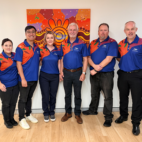 Australian Mutual Bank staff celebrate the Innovate Reconciliation Action Plan launch in uniforms featuring the RAP artwork.